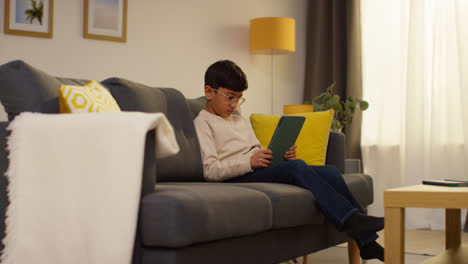 Kleiner-Junge-Sitzt-Zu-Hause-Auf-Dem-Sofa-Und-Spielt-Spiele-Oder-Streamt-Auf-Ein-Digitales-Tablet-7